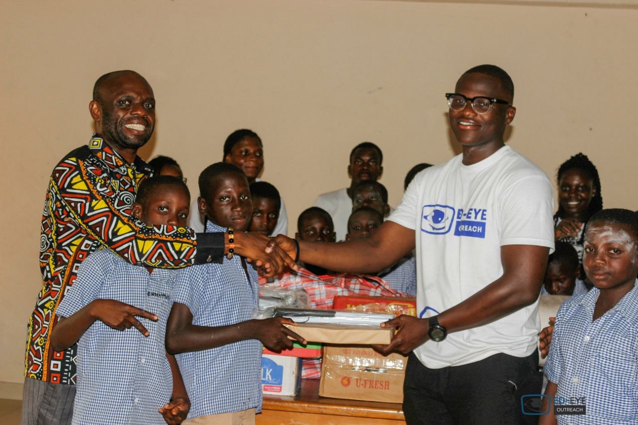 ED-EYE representative and school community members exchanging donated supplies