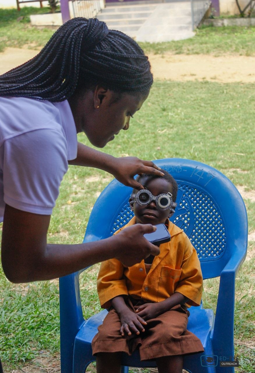 Young school student wearing trial frames during an eye check